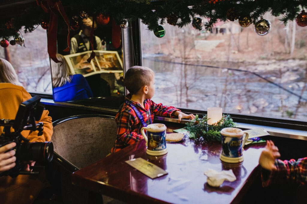 Family boarding the Great Smoky Mountains Railroad Polar Express train in Bryson City, North Carolina during the holiday season. Photo by @bdesignphoto.